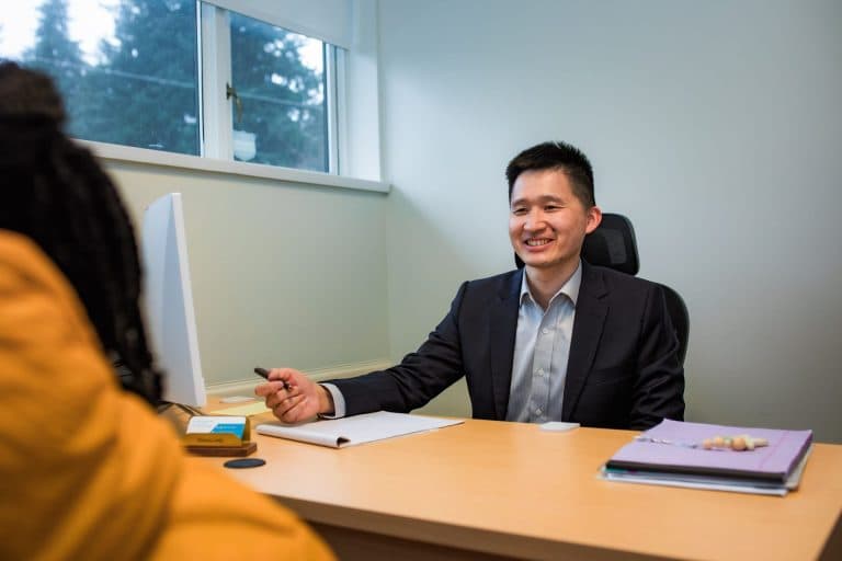 NeuroLinks psychiatrist talking with a patient across a desk during an assessment